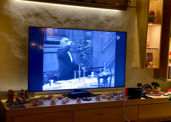 Auf einem Fernseher sieht man eine Szene aus "Dinner for One", unter dem Fernseher ist eine TV-Bank mit Weihnachtsdekoration